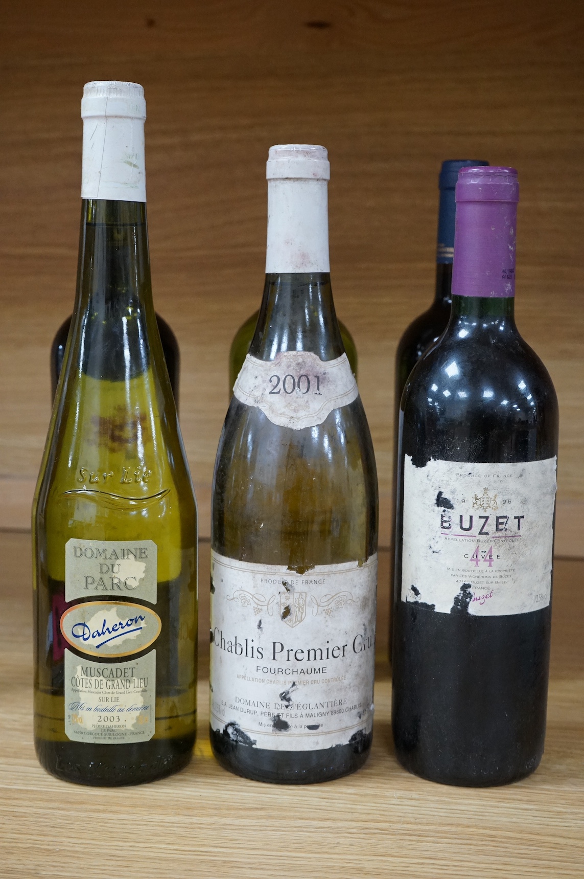 Six bottles of red and white wine to include Chablis Premier Cru 2001, Domaine Du Parc Muscadet 2003, Vin De Bordeaux, Chateau Lafite Monteil Bordeaux Supérieur 2020, Moncade Bordeaux and Buzet 1996. Condition - fair